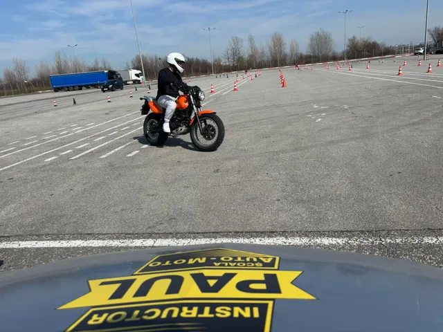 Motociclist pe poligon, motocicletă portocalie